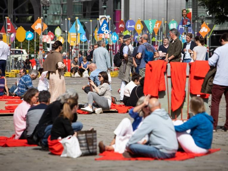 Menschen beim Picknick auf einem Platz.